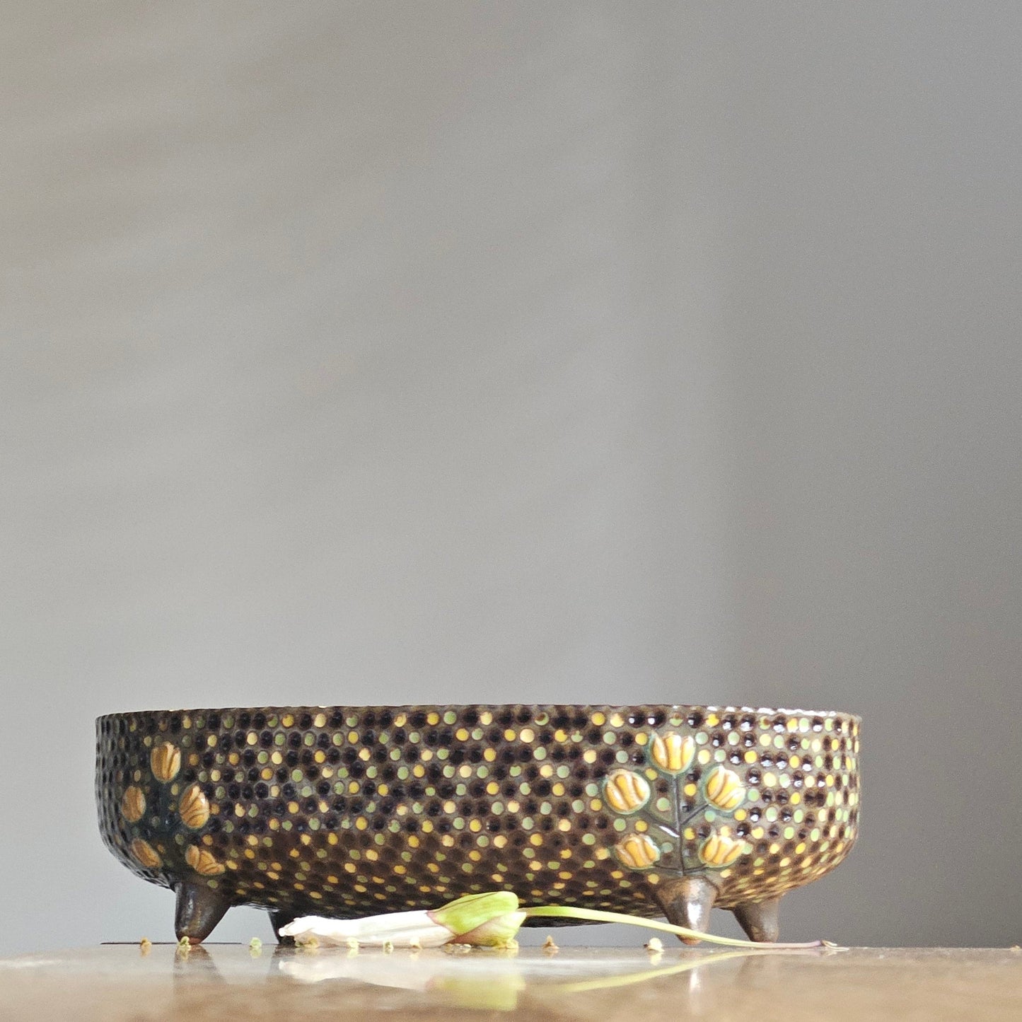 Decorative wall sconce with a textured design on a plain wall.